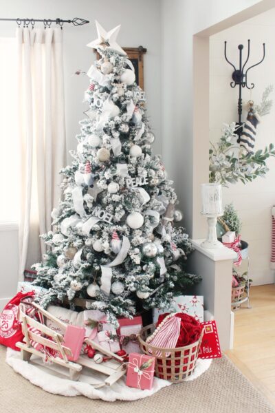 Flocked Christmas tree decorated with white and silver with a few pops of red.