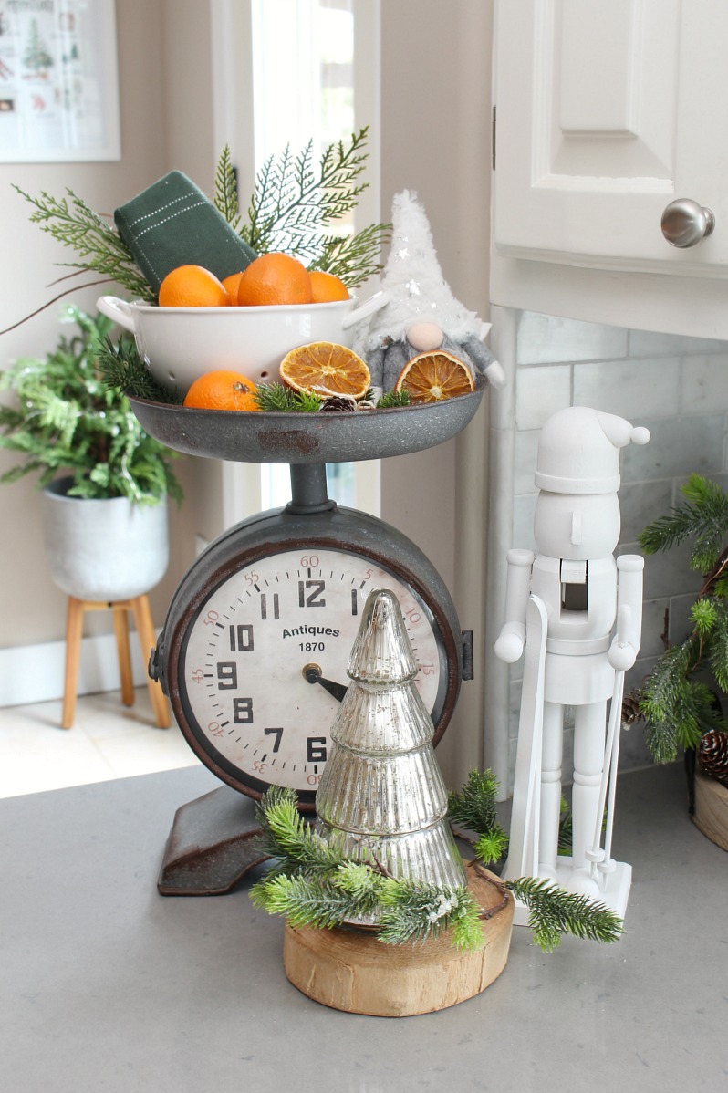 Cute Christmas kitchen decor with oranges and a nutcracker.