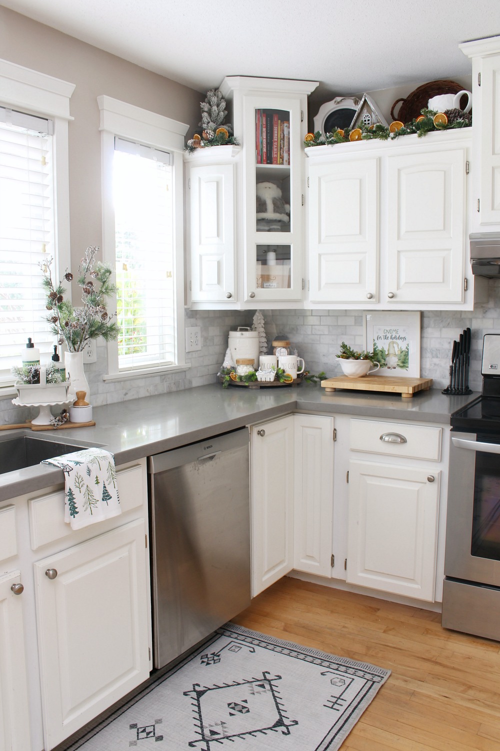 White modern farmhouse style kitchen decorated for Christmas in green and white with dried oranges.