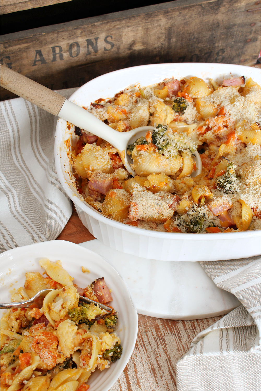 Cheesy vegetable and ham casserole in a baking dish.