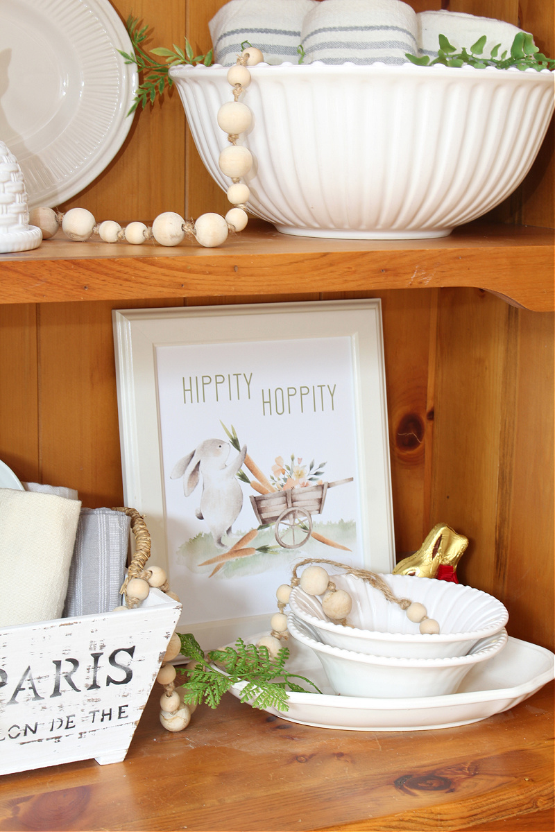 Cute Easter printable on display in a hutch styled for Easter.