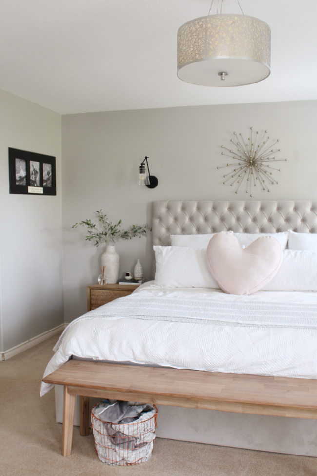 Master bedroom decorated for summer with neutrals and a pop of pink.