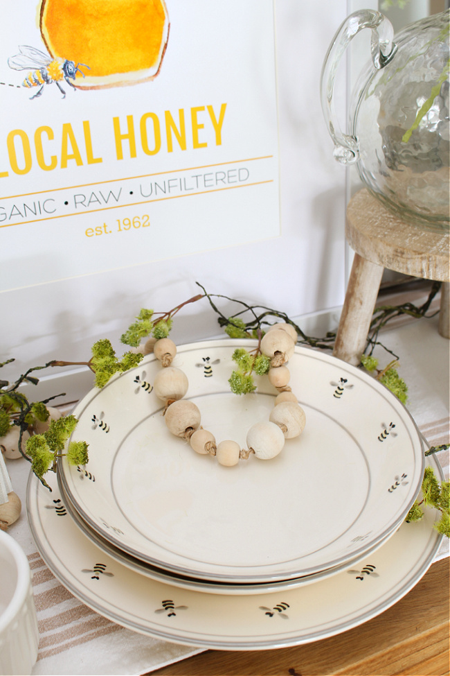 Honey bee decor on a dining room hutch.