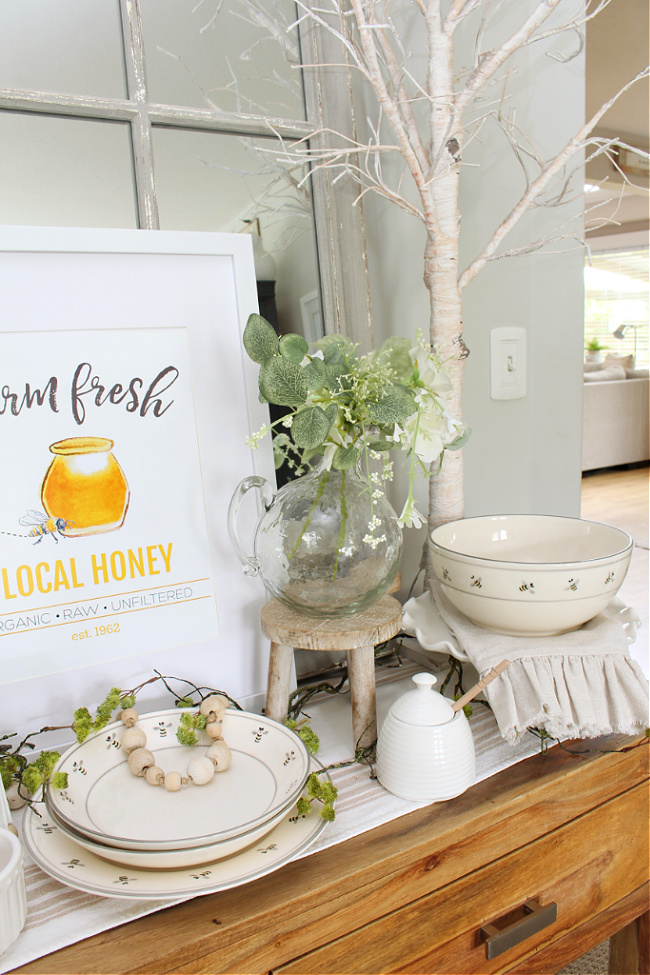 Honey bee decor on a dining room hutch.