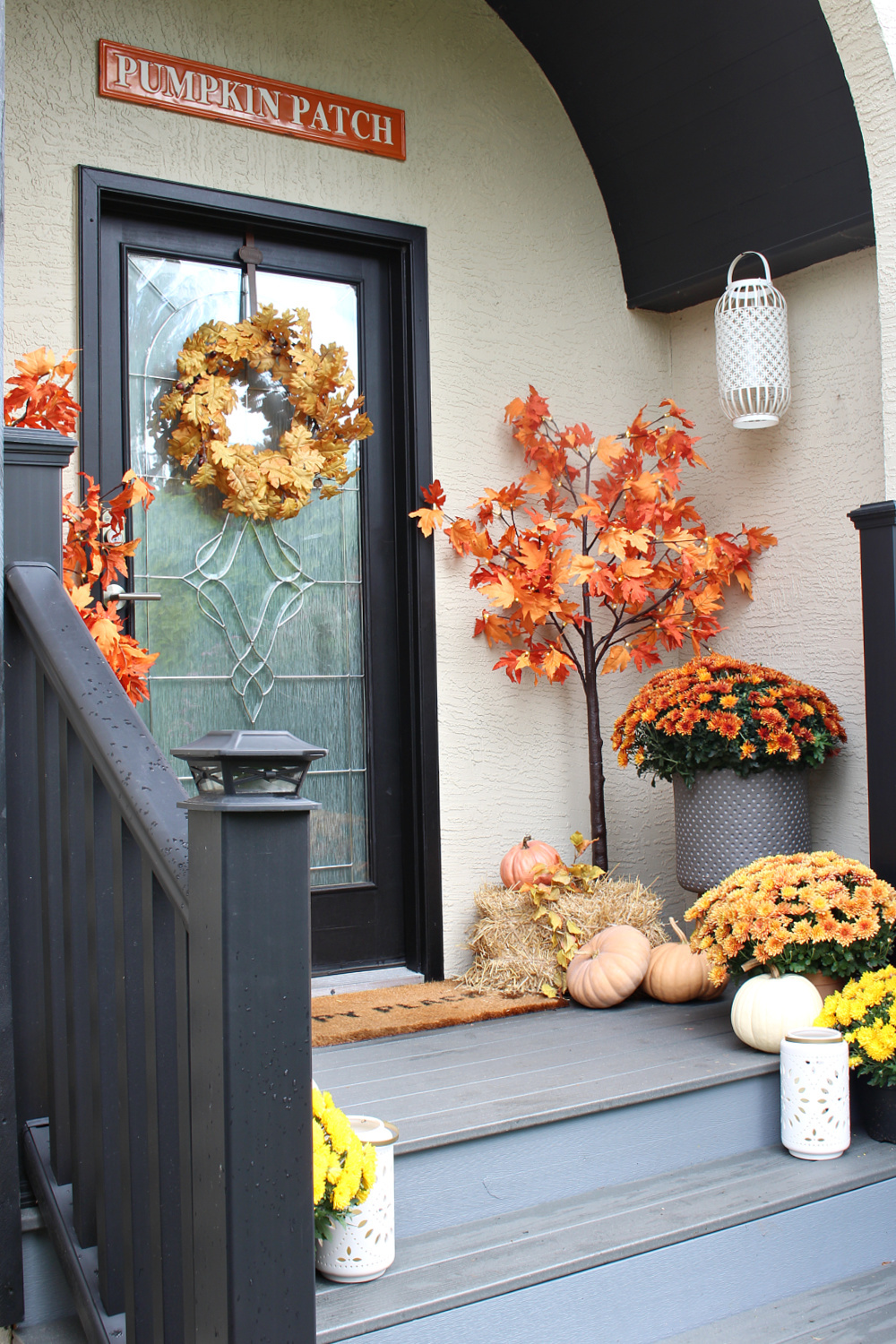 A fall front porch decorated in traditional fall colors.