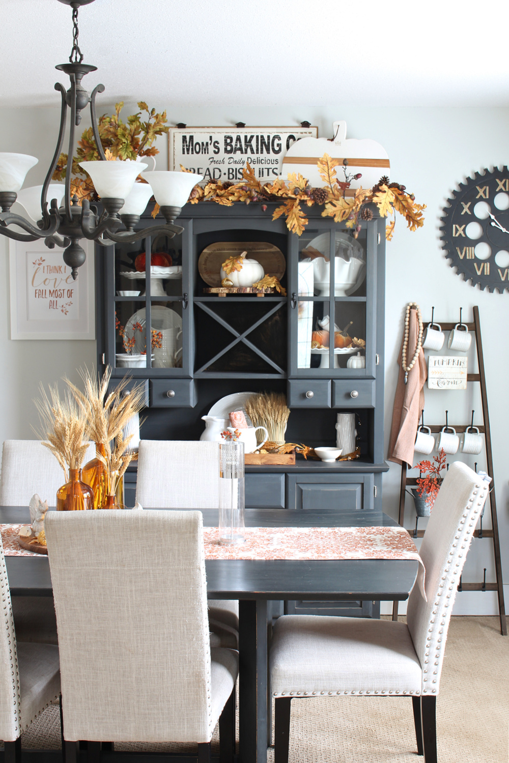 Traditional fall decor colors in a dining room with painted black table and hutch.
