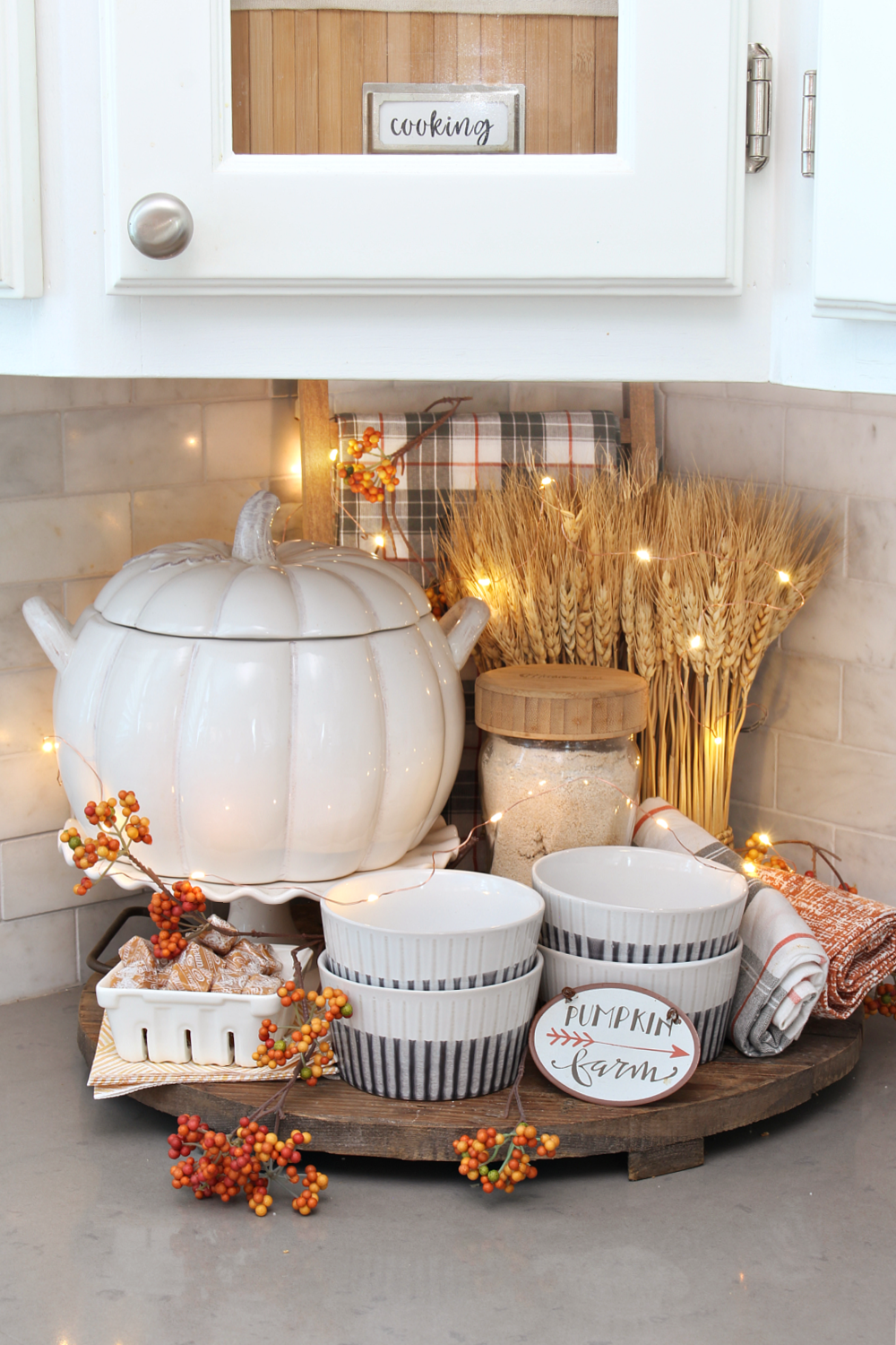 Autumn vignette in kitchen with twinkling lights.