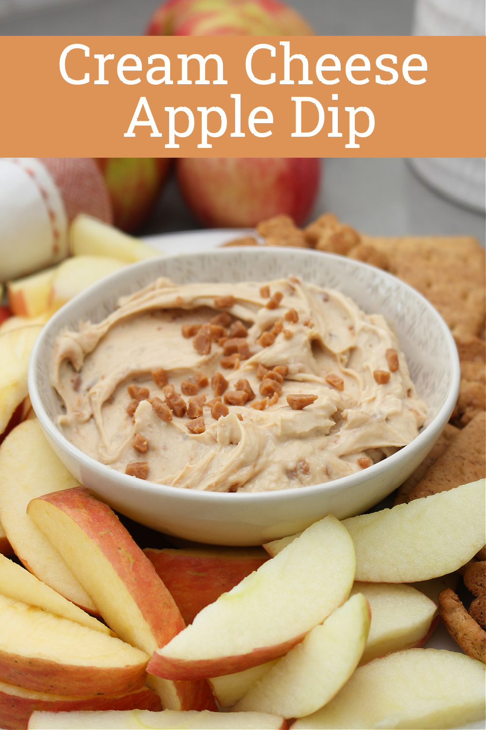Cream cheese apple dip on a plate with apples and graham crackers.