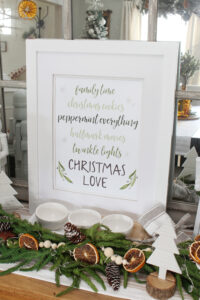 Christmas Love Christmas printable in a frame on a Christmas sideboard.