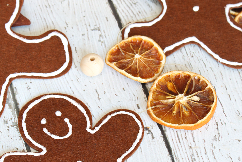 Cute DIY felt gingerbread man garland with dried oranges.