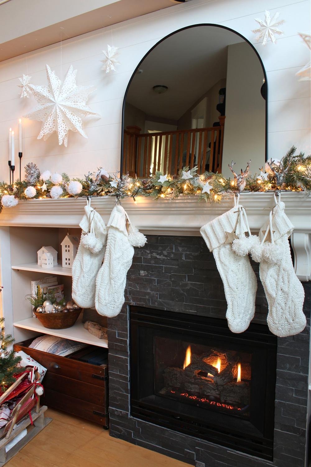 Winter wonderland Christmas mantel with lights and paper snowflakes.