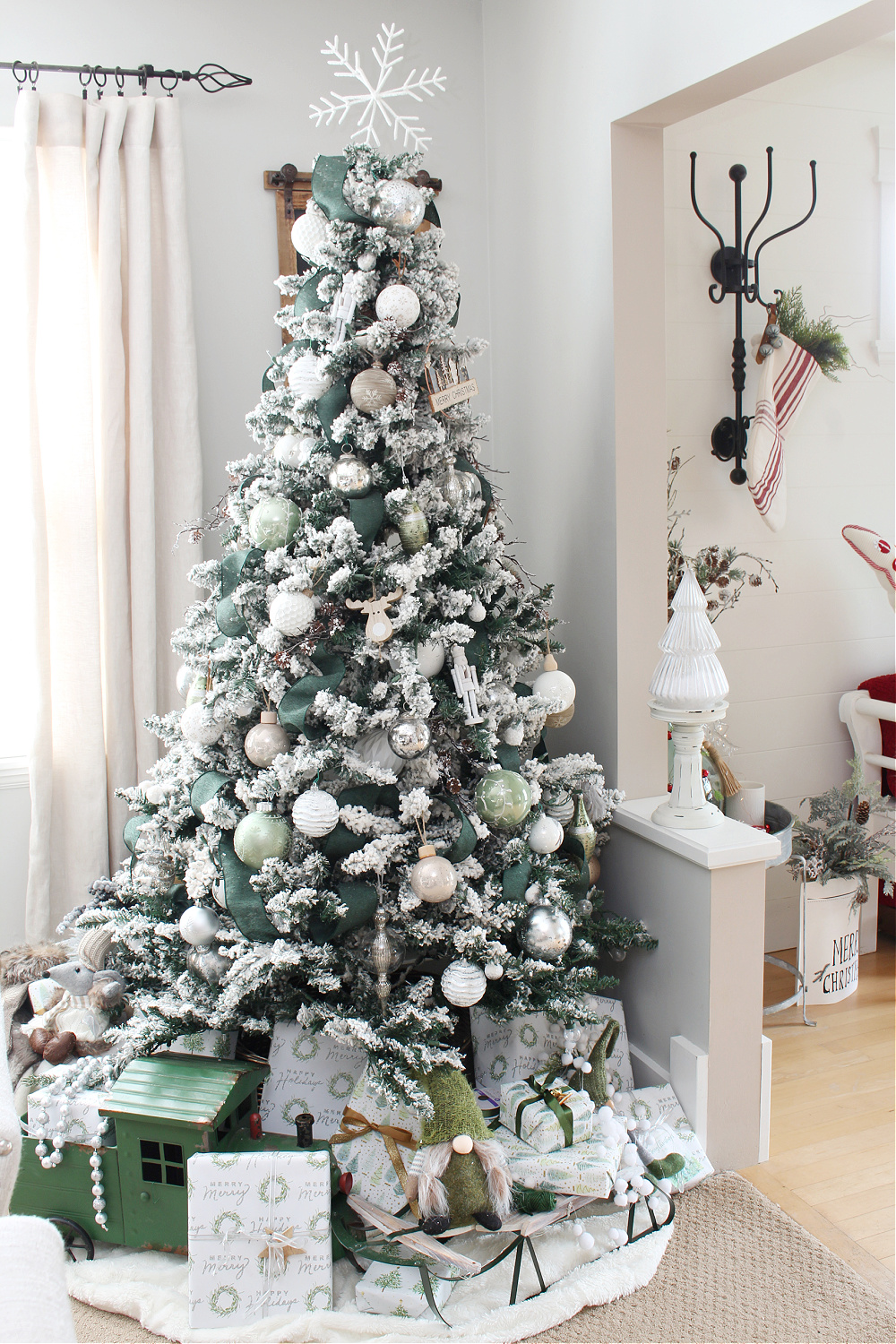 Flocked Christmas tree decorated with green, white and metallics.