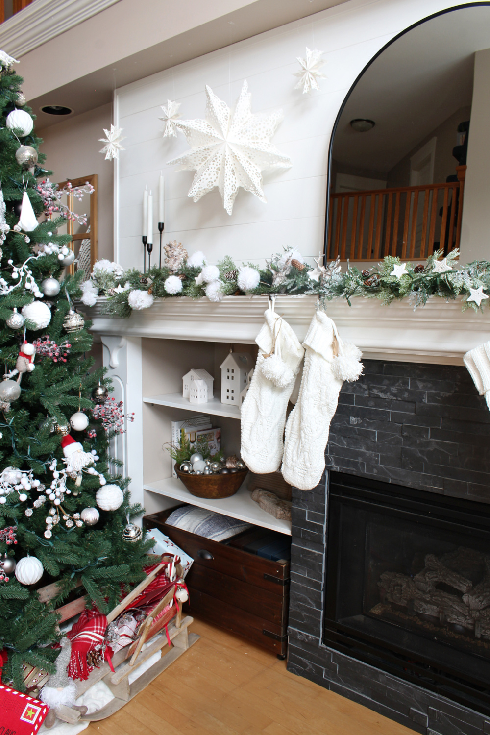 Winter wonderland Christmas mantel with snowball garland and paper snowflakes.
