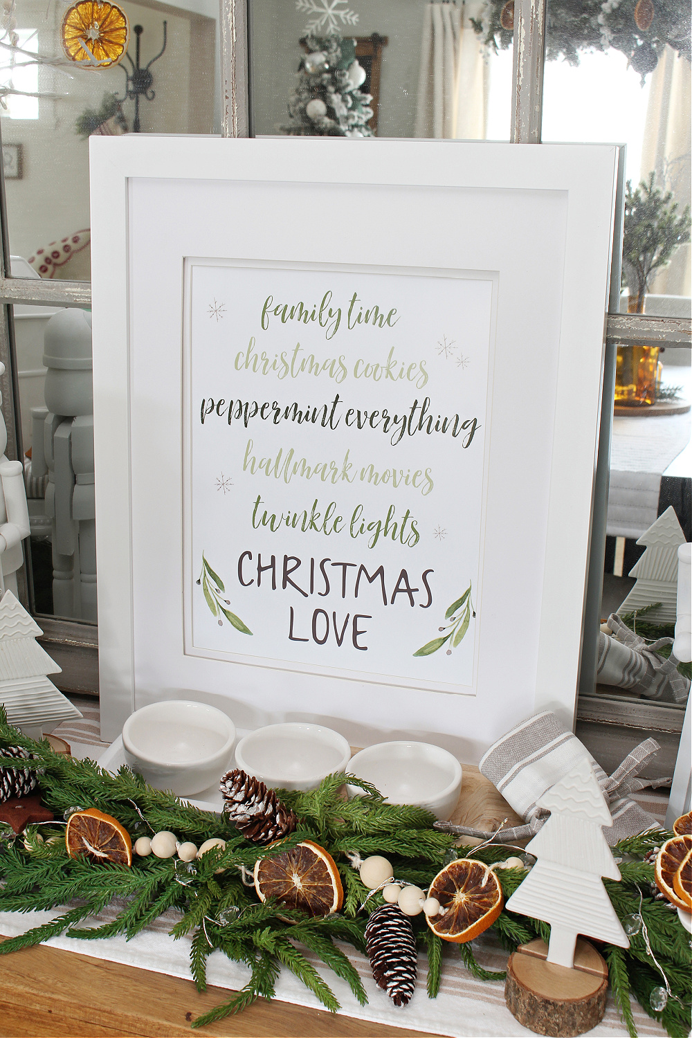 Christmas Love free Christmas printable on a side board with greenery.