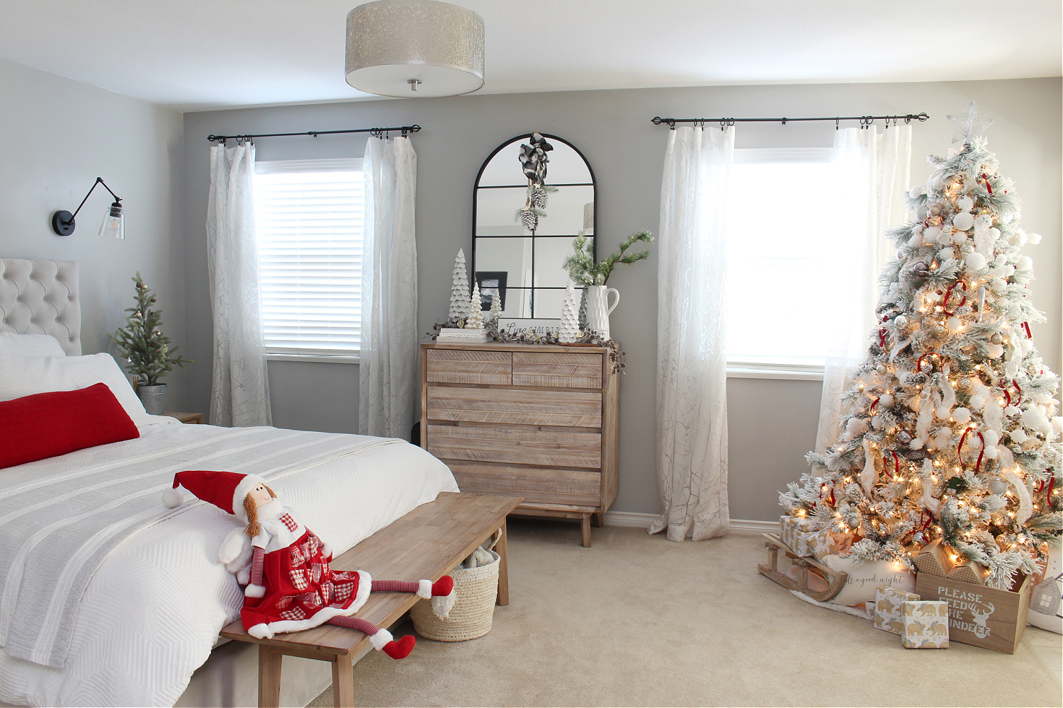Cozy Christmas bedroom with a Christmas tree and pops of red.