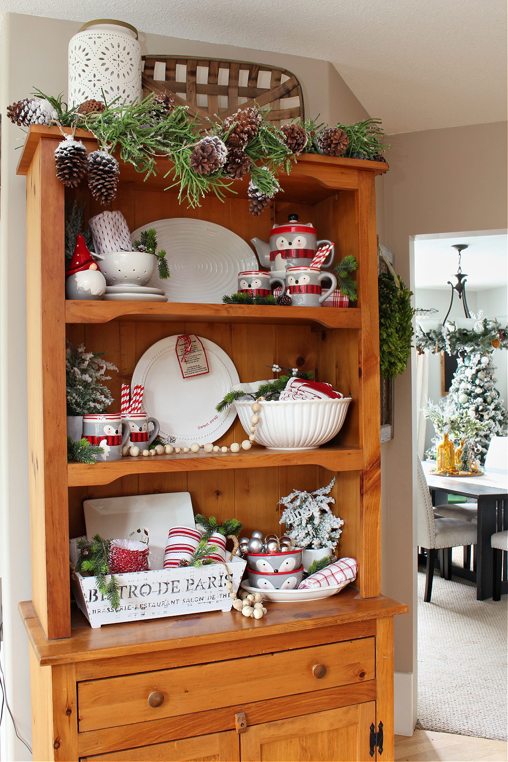 Christmas hutch decorated with a raccoon teapot and mug set.