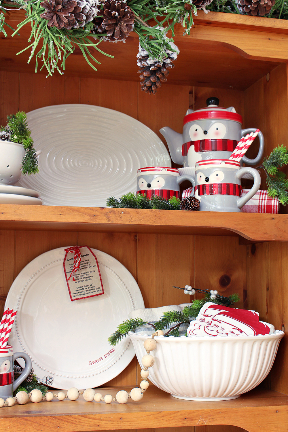 Christmas hutch decorated with a raccoon tea pot and mug set.