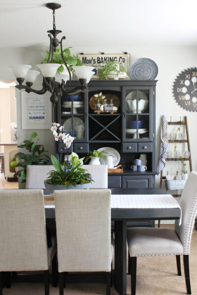 Black hutch and dining room table decorated for summer with blues and greens.