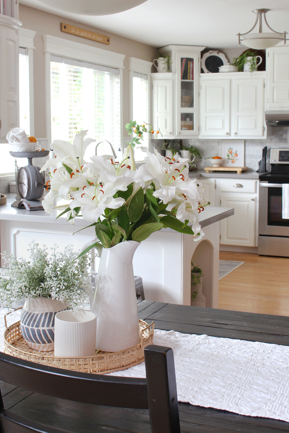 A white kitchen decked out for summer with a pop of orange.