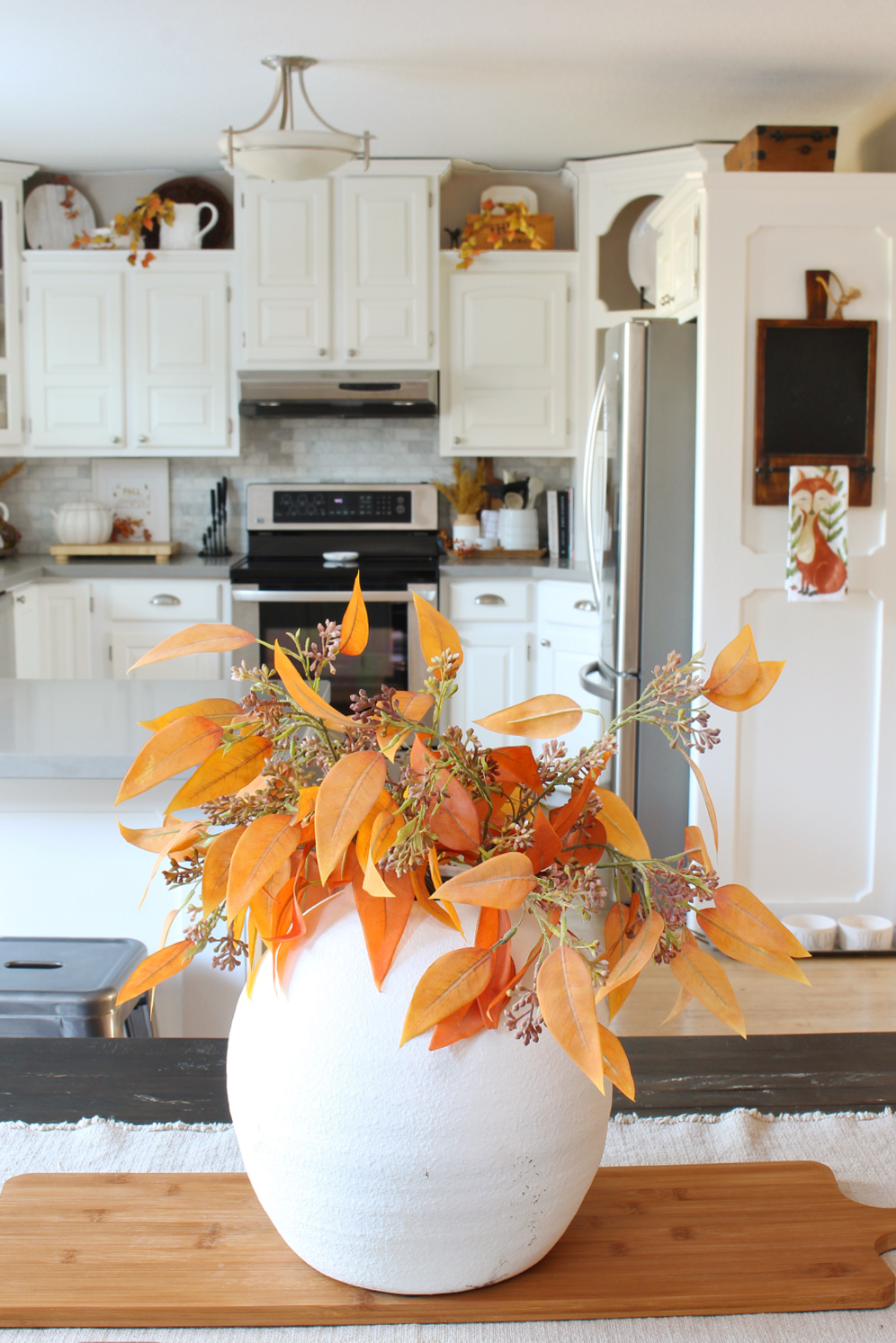 Fall foliage in a white vase for a simple fall centerpiece.