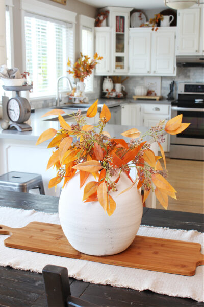 Fall foliage in a white vase for a simple fall centerpiece.