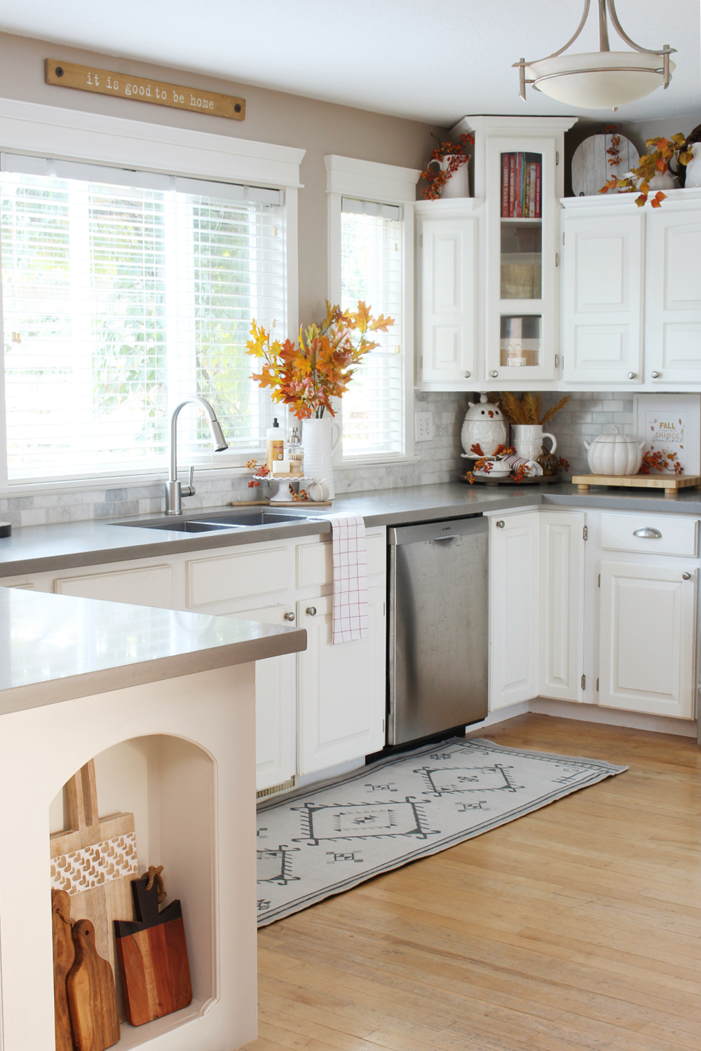 White kitchen decorated for fall with traditional fall colors.