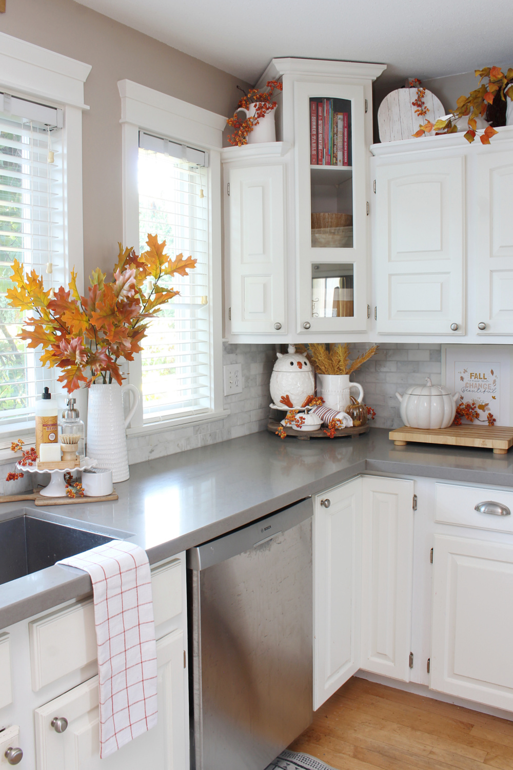 White kitchen decorated for fall with traditional fall colors.