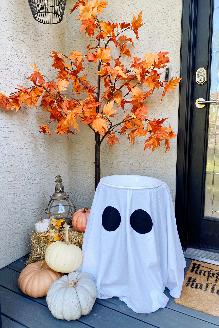 Suporte de doces de Halloween fantasma em uma varanda decorada para o Halloween.