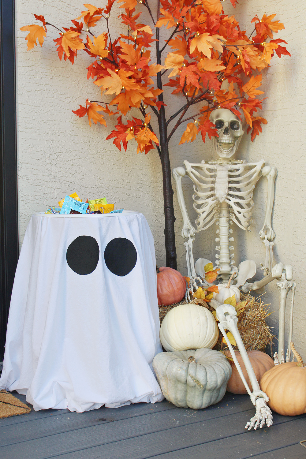 Suporte de doces de Halloween fantasma em uma varanda decorada para o Halloween.