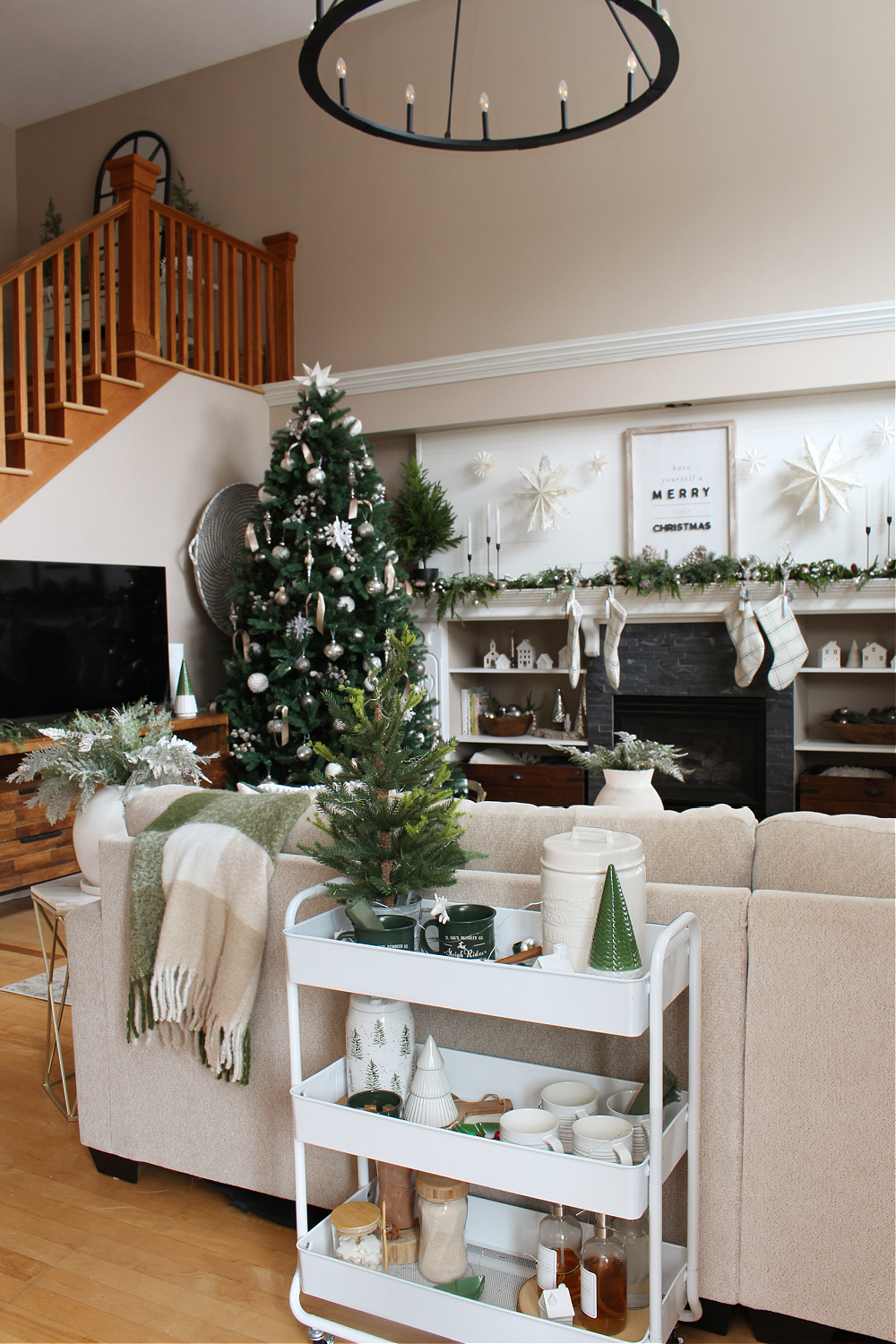 A cozy living room decorated with white and green for Christmas,