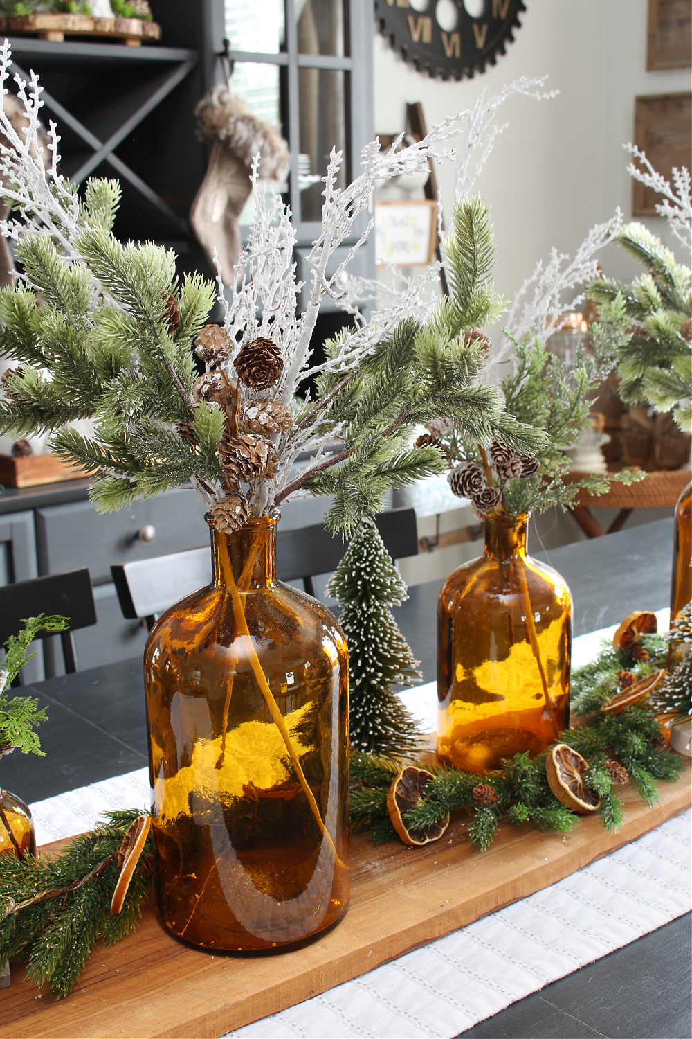 Christmas centerpiece with amber glass and greenery.