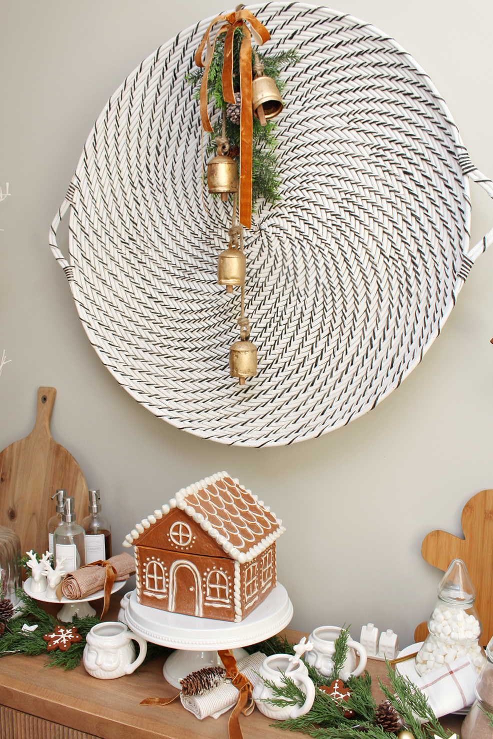 Gingerbread inspired Christmas dining room with gingerbread house cookie jar and large wall basket decorated with garland.