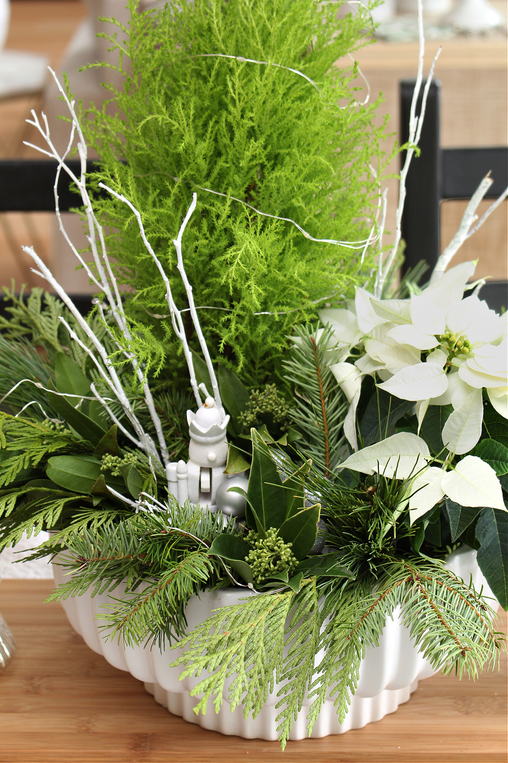 Step by step to create a fresh greenery Christmas centerpiece with a lemon cypress and poinsettia. 